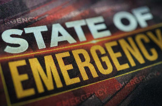 The words State of Emergency are in bold on a dark red and black background.