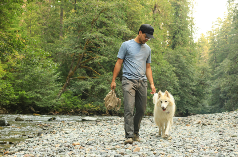 A man walking a dog beside a river