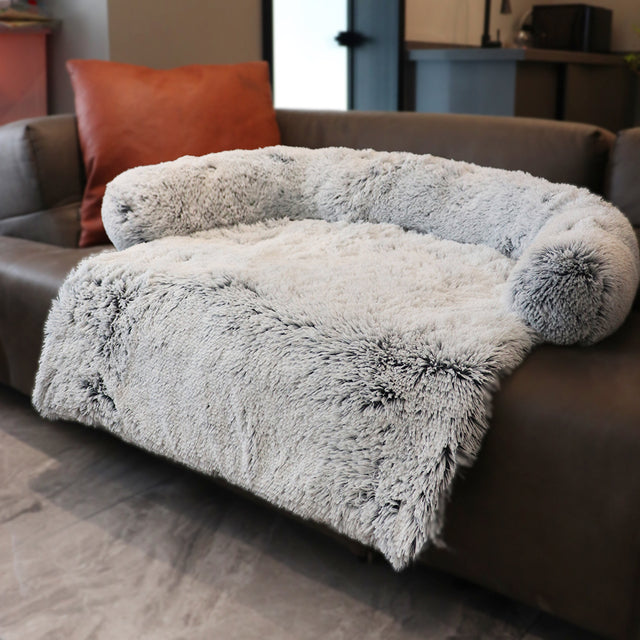 light grey sofa bed on a brown couch in a home setting
