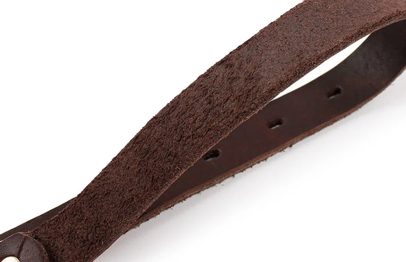 close up of both sides of a brown leather collar, white background. 