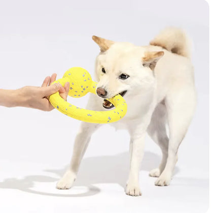 a white dog plays tug-of-war with a yellow rope toy