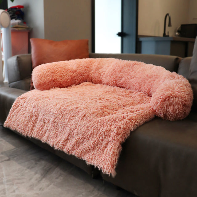 Apricot sofa bed on a brown couch in a home setting.  