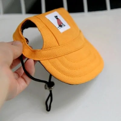 Yellow Pet  Baseball Cap in a person's hand against a white and black background. 