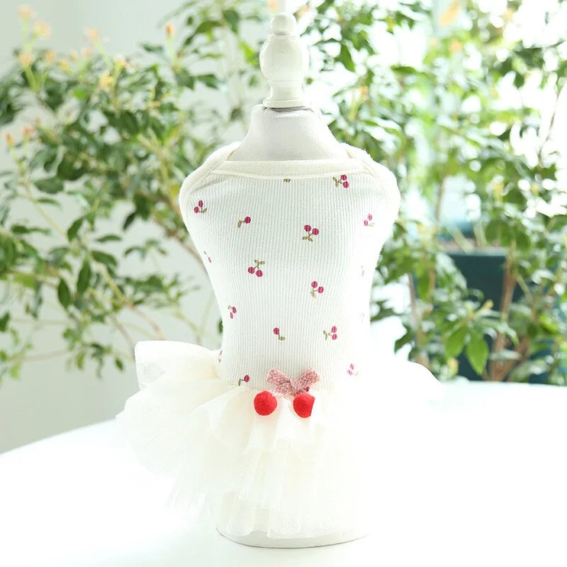 Cherry Delight Dog Dress on a mannequin, green foliage sets the background 