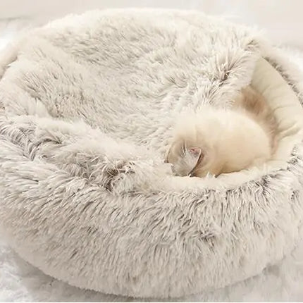 kitten sleeps in a grey snuggle bed in a home setting