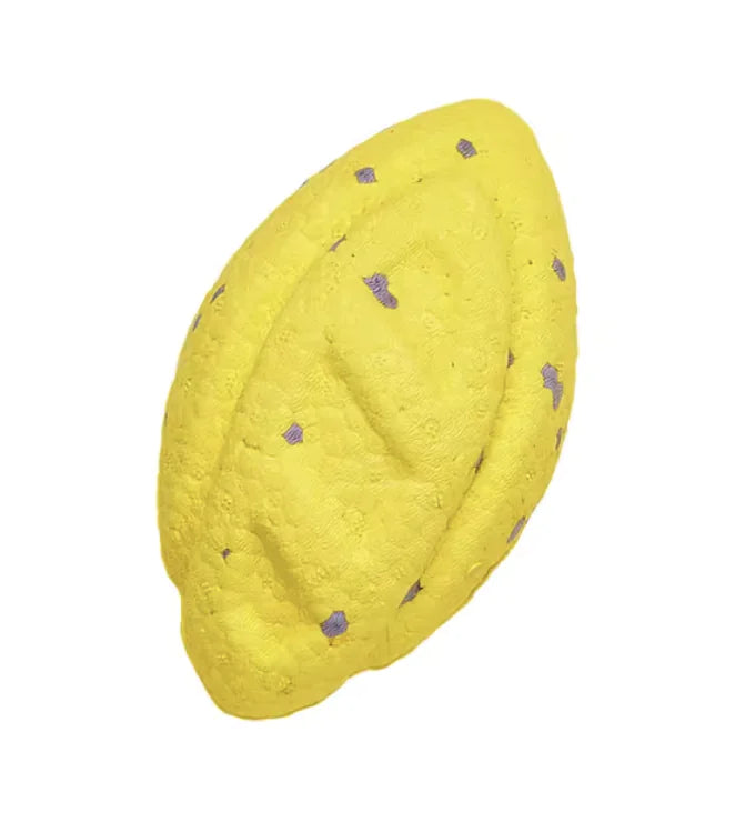 yellow football shape chew toy on white background