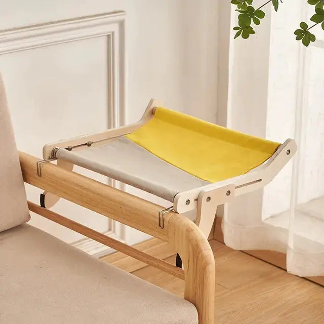 Yellow Feline Window Perch shown attached to a chair, in a home setting. 