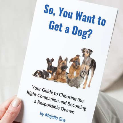 Hand holding the book - So, You Want to Get a Dog? 