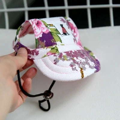 Floral Pet  Baseball Cap in a person's hand against a white and black background. 