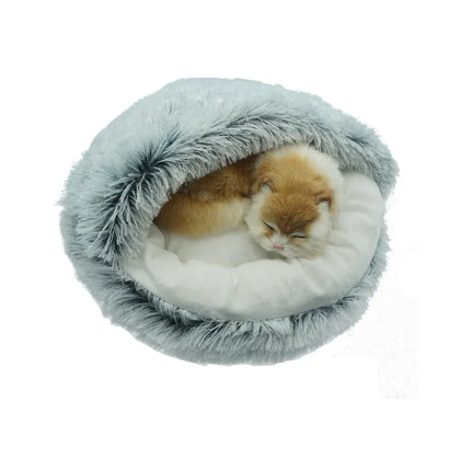a ginger cat sleeps in a snuggle bed