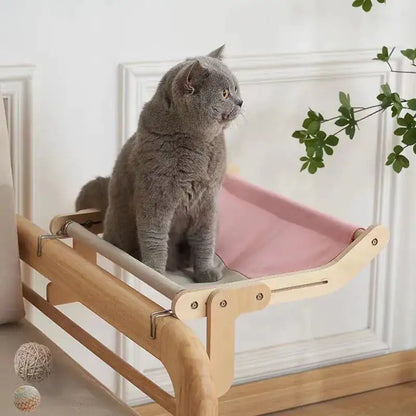 A grey cat sits on a Feline Window Perch in a home setting