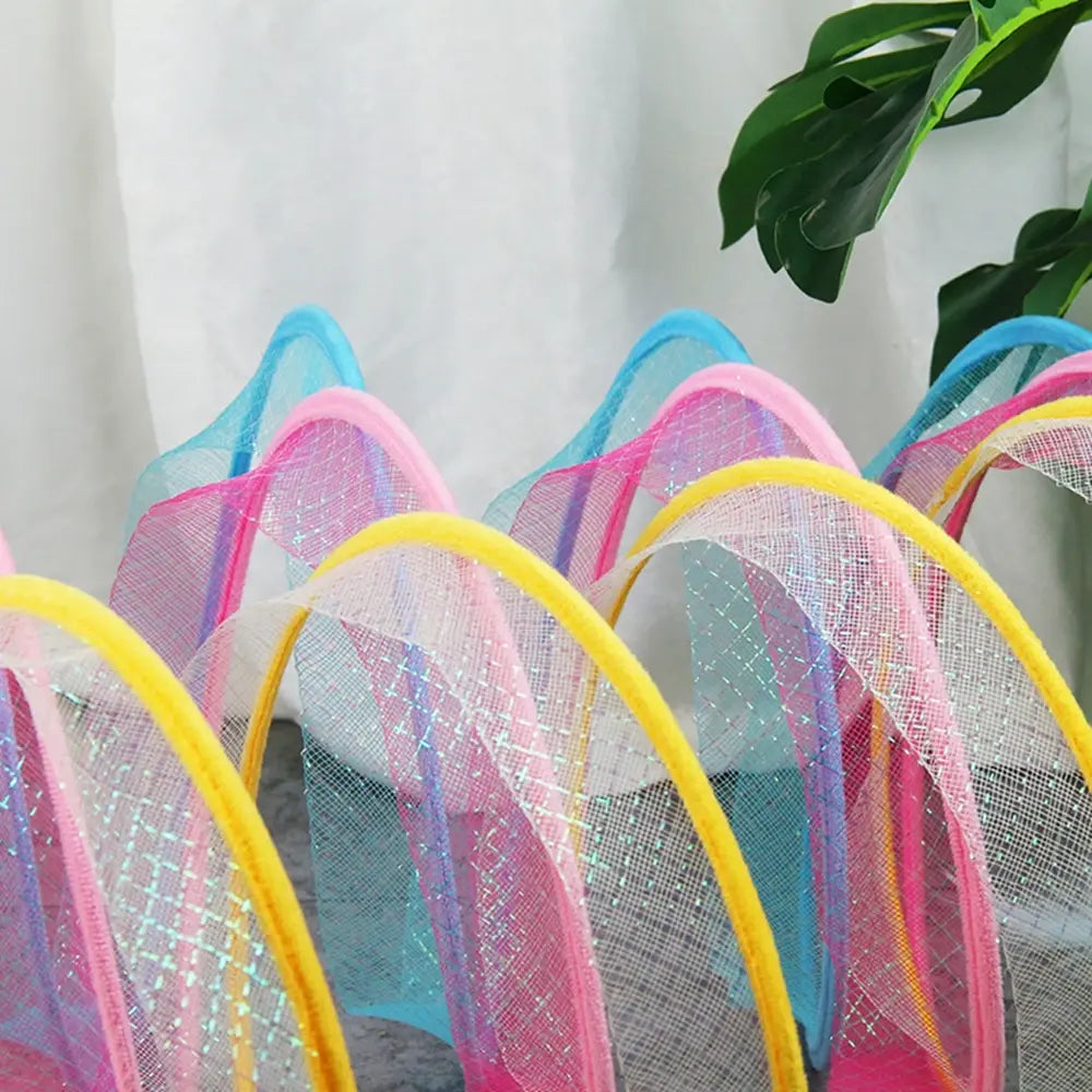 close up image of a blue, yellow and pink Whisker Wonderland Cat Tunnel in a home setting. 