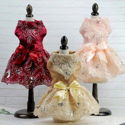 Pink, red and champagne colored dresses on racks, white brick background