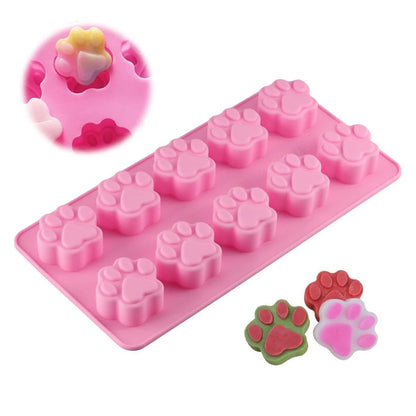 Pink Paw shaped Treat Mold on a white background, smaller images in the foreground show a close up of the paw shape treats. 