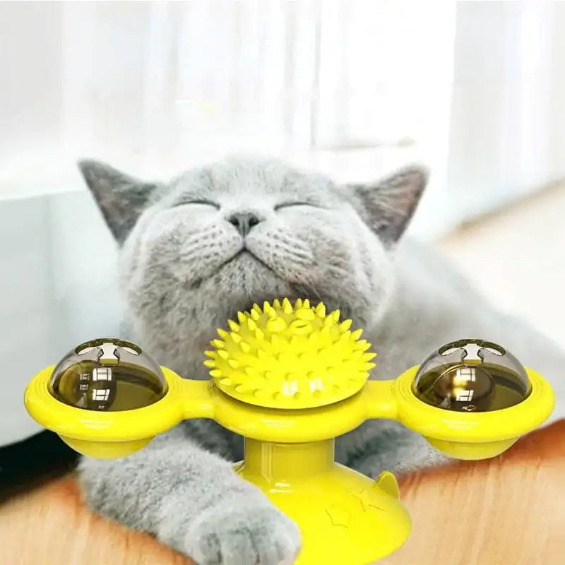 A grey cat rubs his face against a yellow Purrfect Spin-N-Twist Cat Toy in a home setting