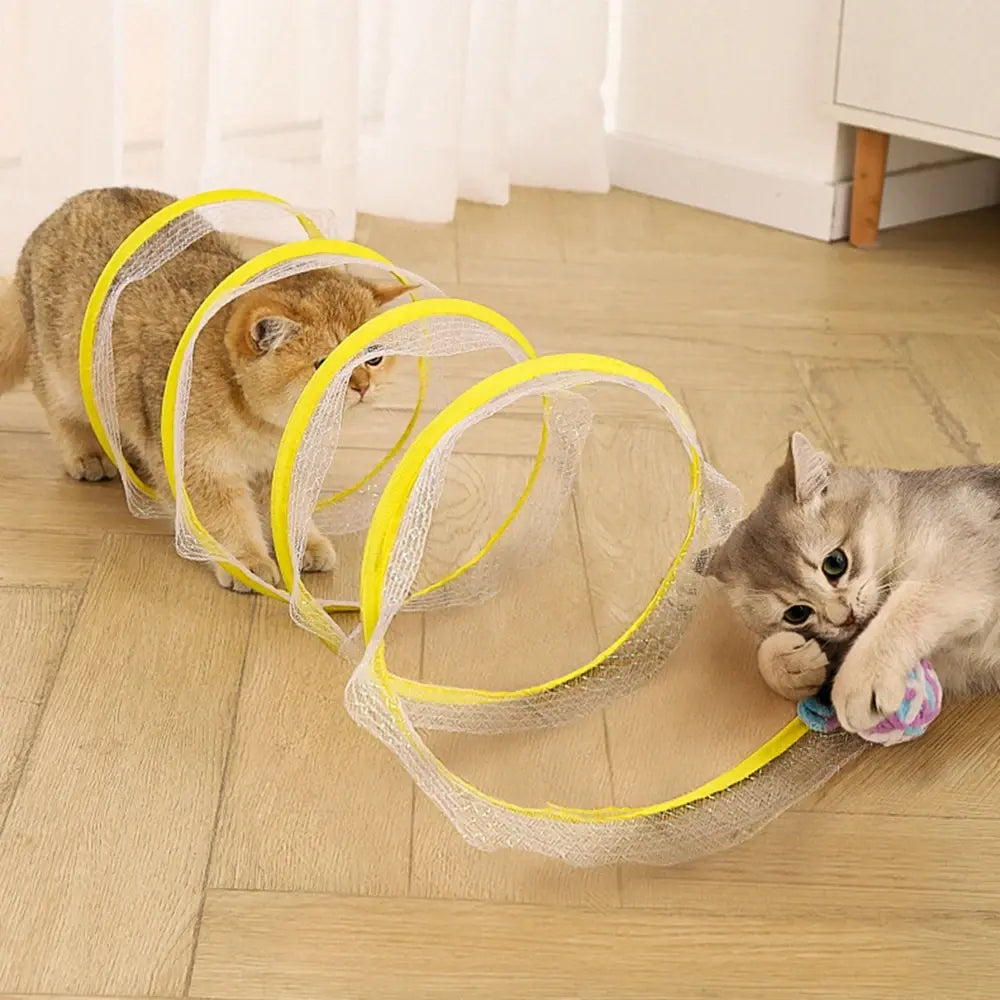 two cats play with a yellow Whisker Wonderland Cat Tunnel in a home setting 