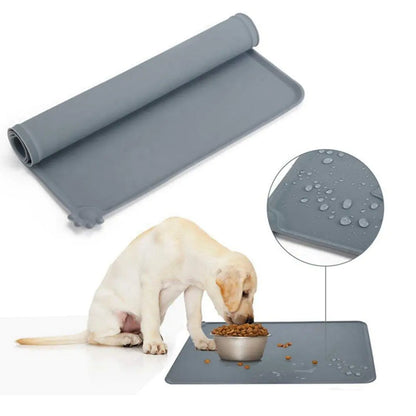 Labrador pup eats from a bowl on a grey Ultimate Silicone Pet Bowl Mat, white background. smaller inset shows water resistance. 