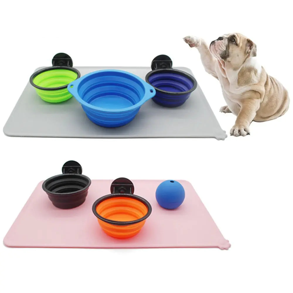 A British Bulldog raises a paw, sitting next to a grey Ultimate Silicone Pet Bowl Mat on a white background. 