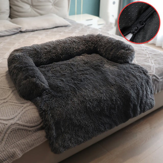 Dark grey sofa bed in a bedroom setting, the sofa bed is positioned at the base of the bed, a smaller inset image shows the zipper, for easy cleaning. 