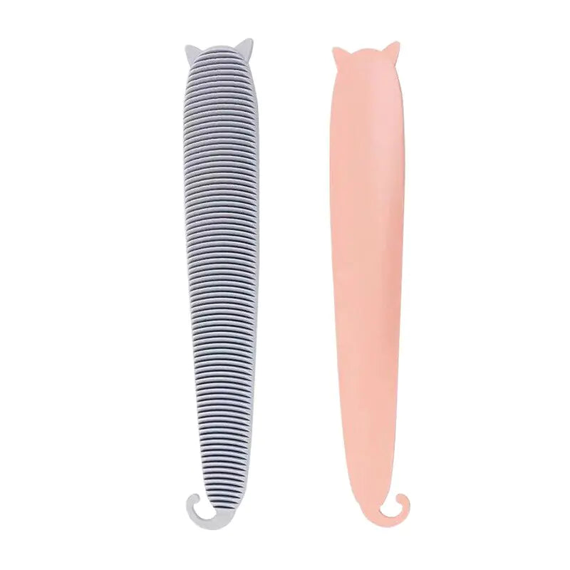 white background, two pet hair remover brushes in the forefront, one pink, one grey.