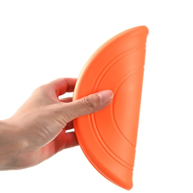 An orange Seven color variants of the Soft Non-Slip Flying Disc being folded in half, on a white background. 