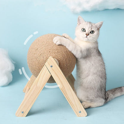 Silver and white cat, sits on back legs, with front paws resting on the cat scratching ball. Blue background, image shows directional arrows to indicate the ball rolls. 