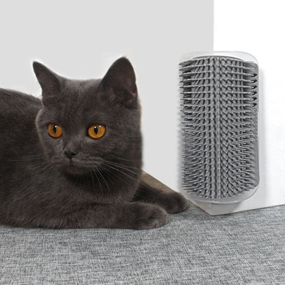 Gray short-haired cat lying comfortably on the floor next to a gray wall brush attached to a white wall.