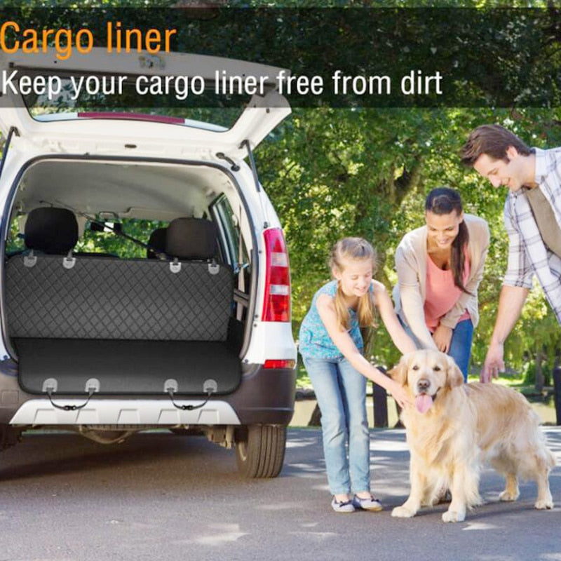 Out door setting, showing a family next to their car, petting a Golden Retriever. The back of the car is opened, to show the seat cover being used in the rear of the vehicle. 