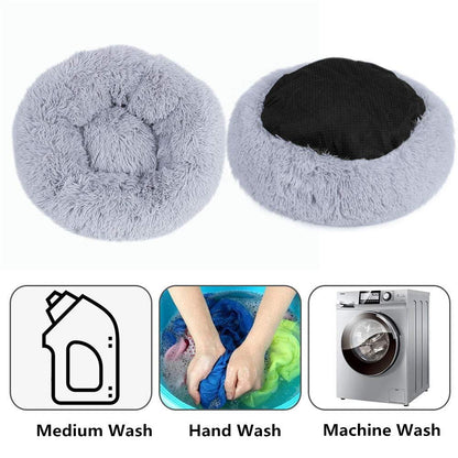 Main image shows light grey donut bed in two positions - one up and one upside down. Three insets below show a washing liquid bottle with text medium wash, the second image shows a person hand washing and the third showing a washing machine indicating the product can be machine washed. 