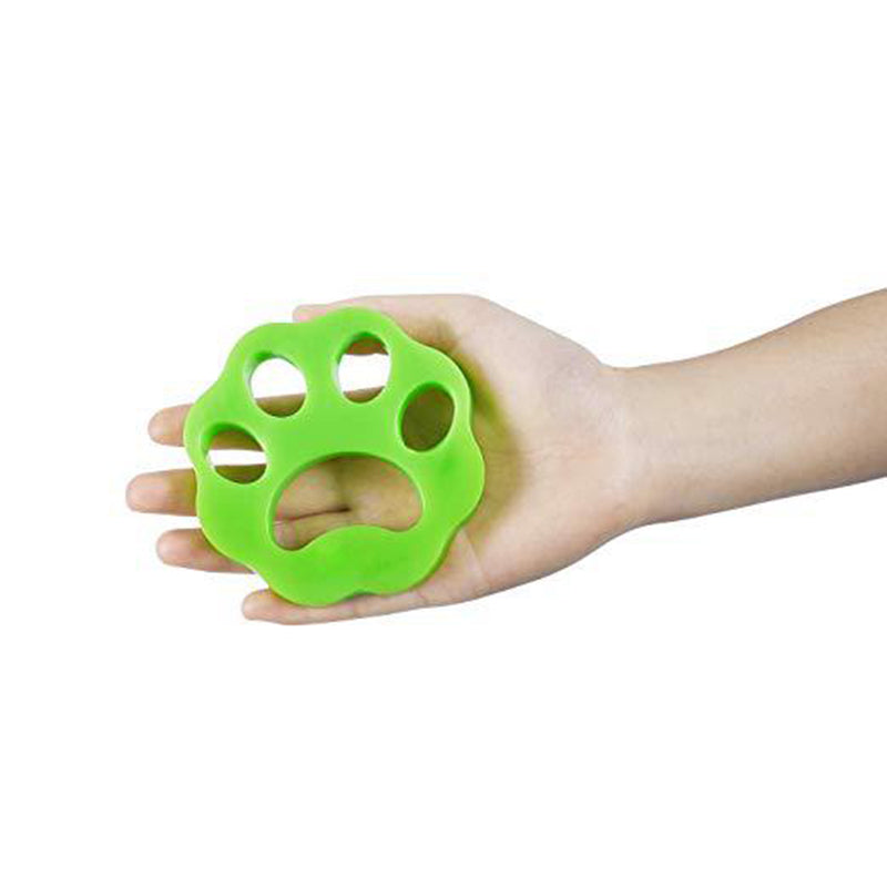 green pet hair removal disk in a person's palm on white background. 