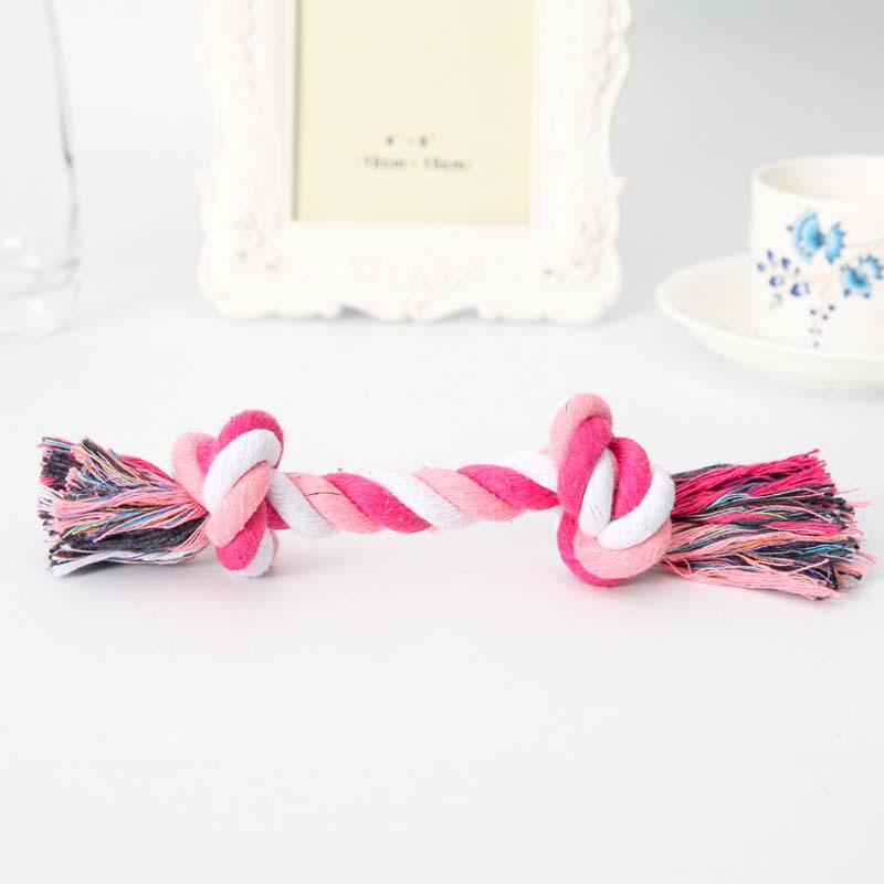 pink and white rope toy on white background