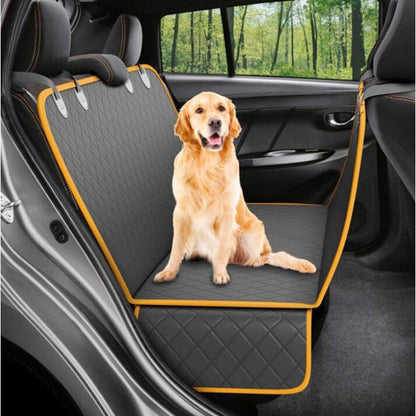 Golden Retriever sitting in the back of a vehicle on a pet car seat cover. outdoor setting. 