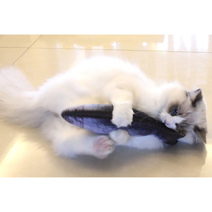 white fluffy cat playing on the floor, hugging fish shaped toy. 